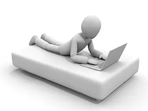 ベッドのような台の上でうつ伏せになり、ノートパソコンを操作している白い3D人物のイラスト